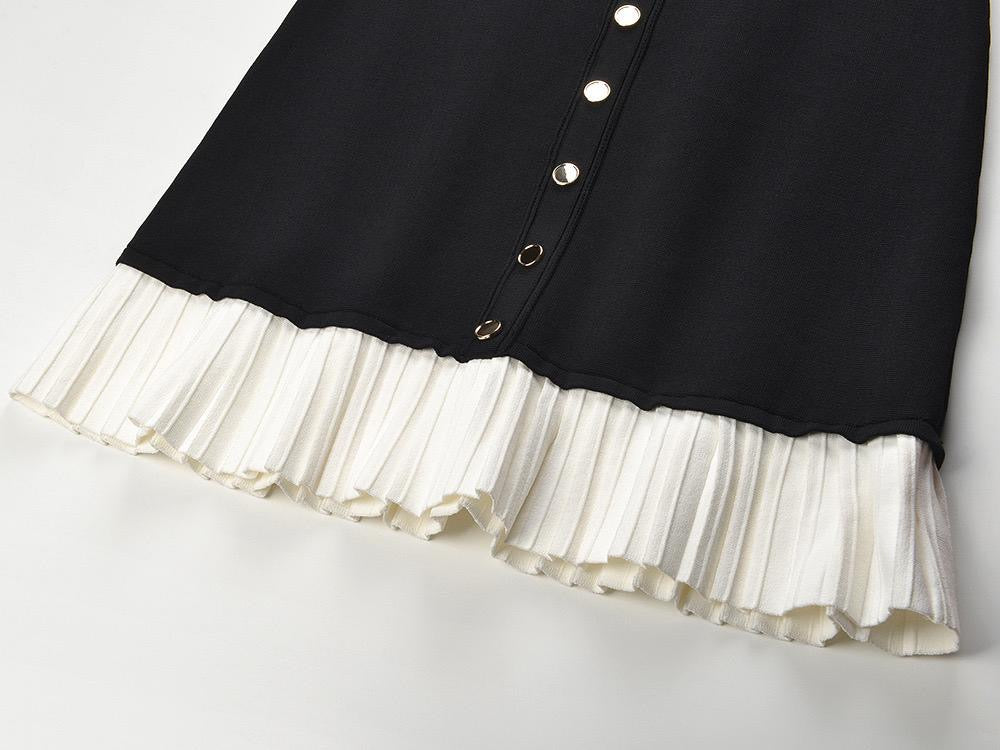 Black fitted dress with statement gold buttons and a playful pleated hem